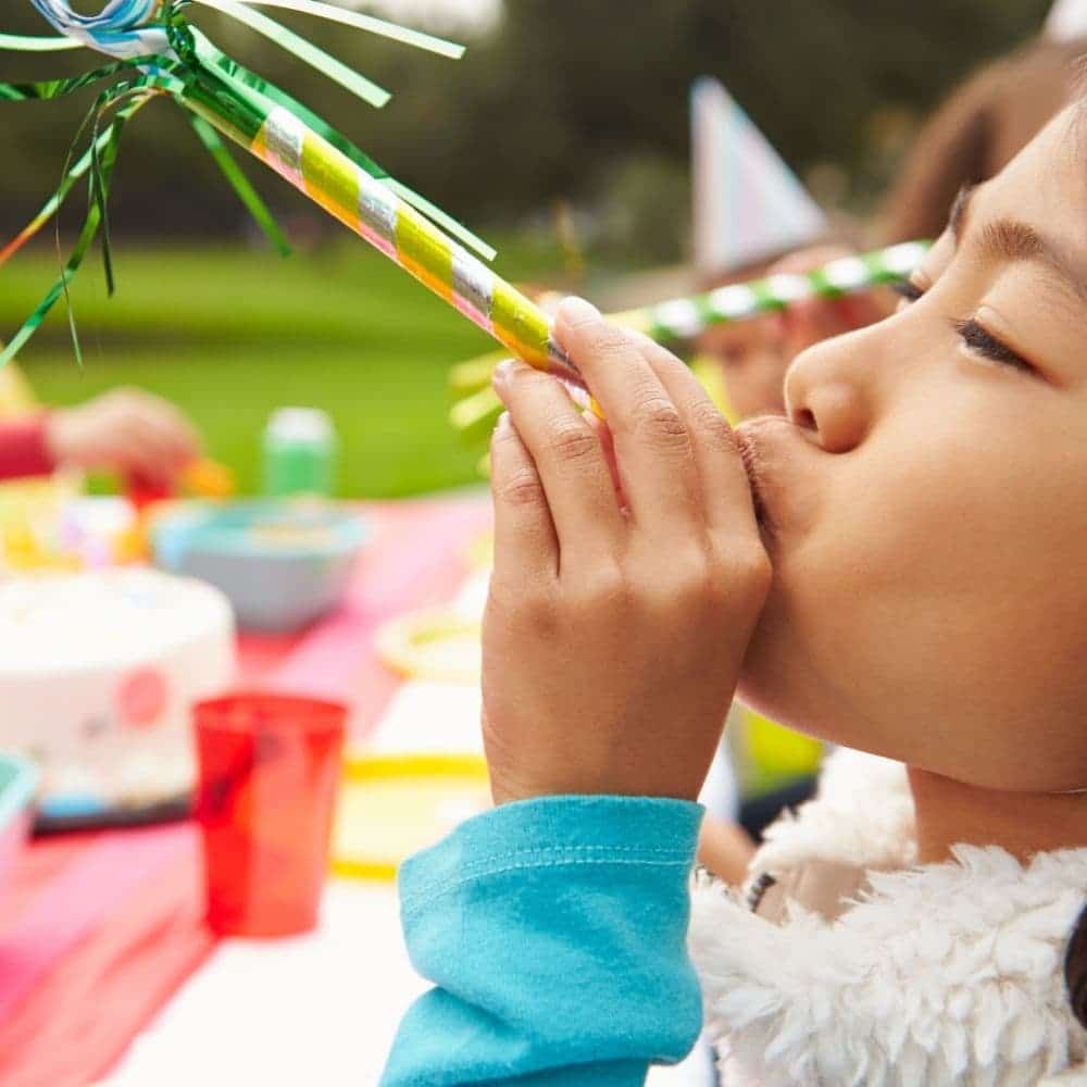 a girl blowing a party horn